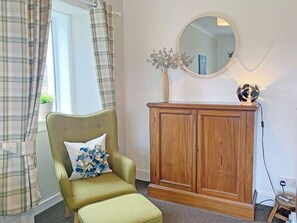 A room with a green armchair, a wooden cabinet, a mirror, and a window with curtains. - 3 bedroom accommodation in Kilmichael Glassary, near Lochgilphead (Kilmichael Glassary, near Lochgilphead)