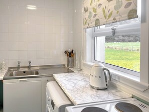 A kitchen with a sink, a kettle, and a window with a view of a green field. - 3 bedroom accommodation in Kilmichael Glassary, near Lochgilphead (Kilmichael Glassary, near Lochgilphead)