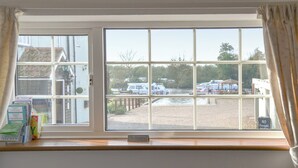 A view through a window with a 'NO SMOKING' sign, a 'NO Overnight Parking' sign, and a glimpse of boats and a building in the background. - 1 bedroom accommodation in Horning, near Norwich (Horning, near Norwich)