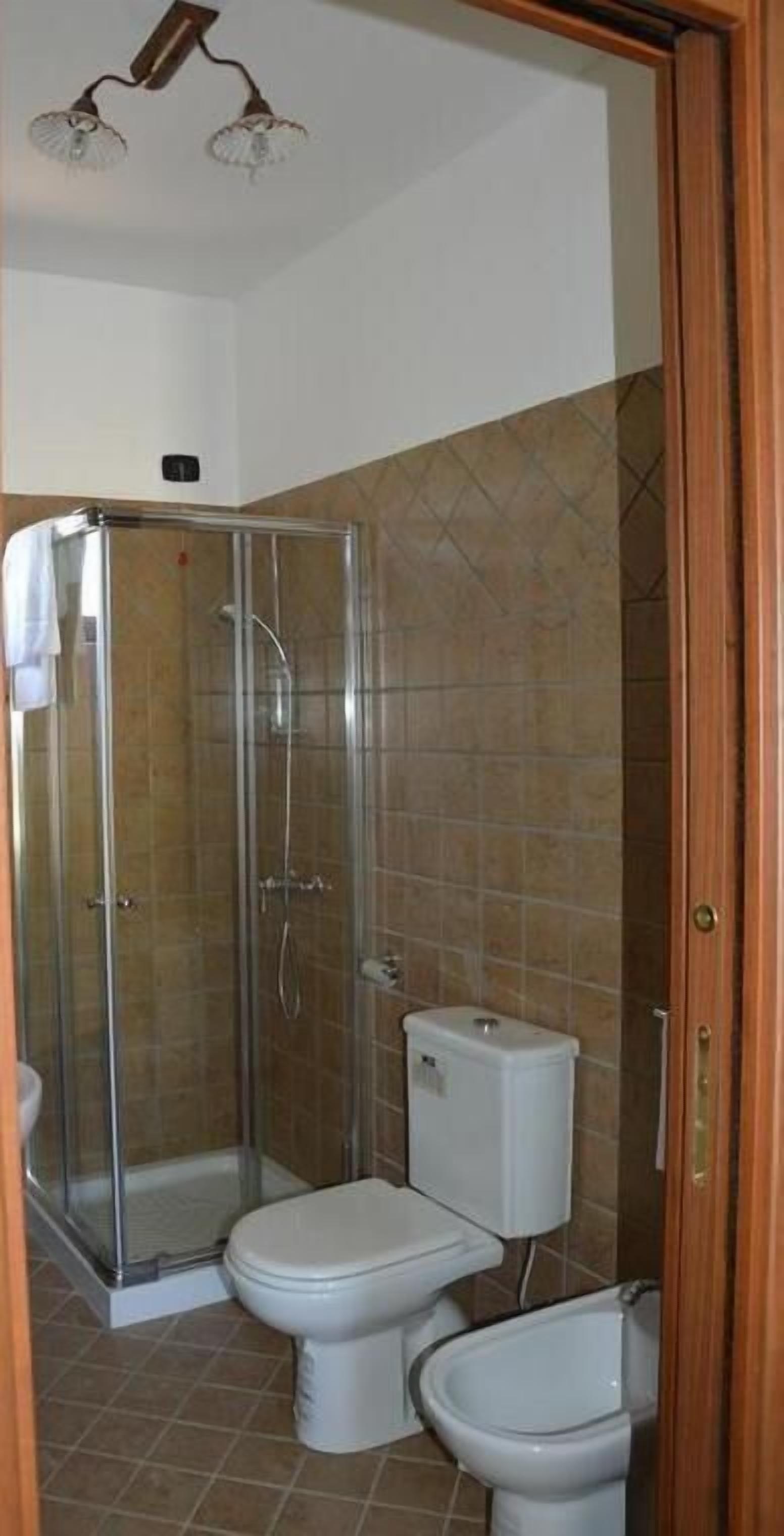 Un baño con ducha de vidrio, inodoro y bidé.