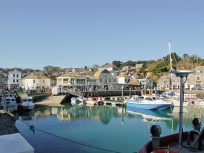 A harbor with boats docked, a clear sky, and buildings in the background. - Enjoy distant sea views whilst relaxing amidst the stunning rural surroundings. (St Merryn, near Padstow)