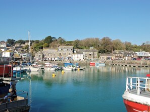 A harbor with boats docked, buildings along the shore, and a clear sky. - Enjoy distant sea views whilst relaxing amidst the stunning rural surroundings. (St Merryn, near Padstow)