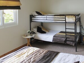A bunk bed room with a small table and a window. - Enjoy distant sea views whilst relaxing amidst the stunning rural surroundings. (St Merryn, near Padstow)