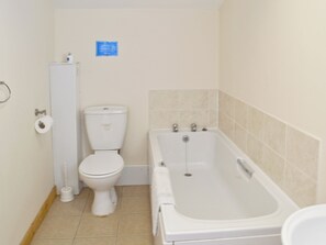 A small, clean bathroom with a toilet, a sink, and a bathtub. - 2 bedroom accommodation in Flamborough (Flamborough)