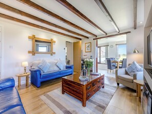 A living room with a blue sofa, wooden coffee table, and a fireplace.