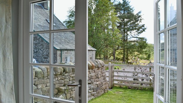 A stone wall and a wooden fence with a gate, leading to a grassy area. - 1 bedroom accommodation in near Comrie and Crieff (near Comrie and Crieff)