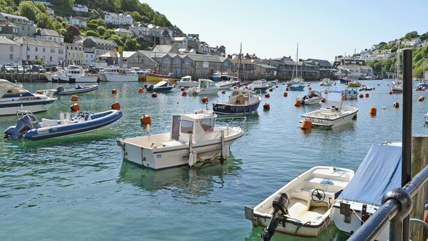 A harbor with various boats docked, surrounded by residential buildings. - 1 bedroom accommodation in Looe (Looe)