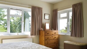 A bedroom with a bed, dresser, and a window with curtains. - 3 bedroom accommodation in Potterne, near Devizes (Potterne, near Devizes)