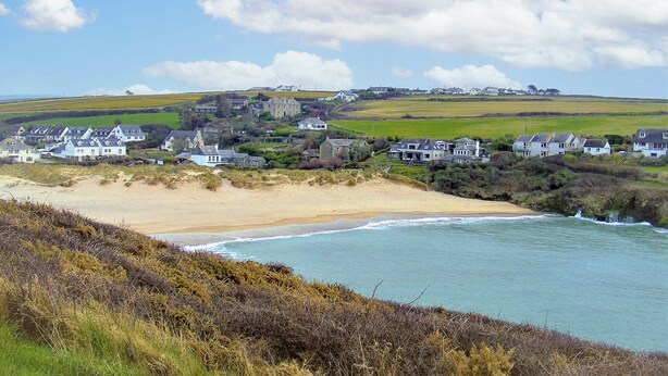 A coastal village with houses, a beach, and a view of the sea.