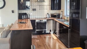 Una cocina compacta con encimera de madera, horno empotrado y microondas.