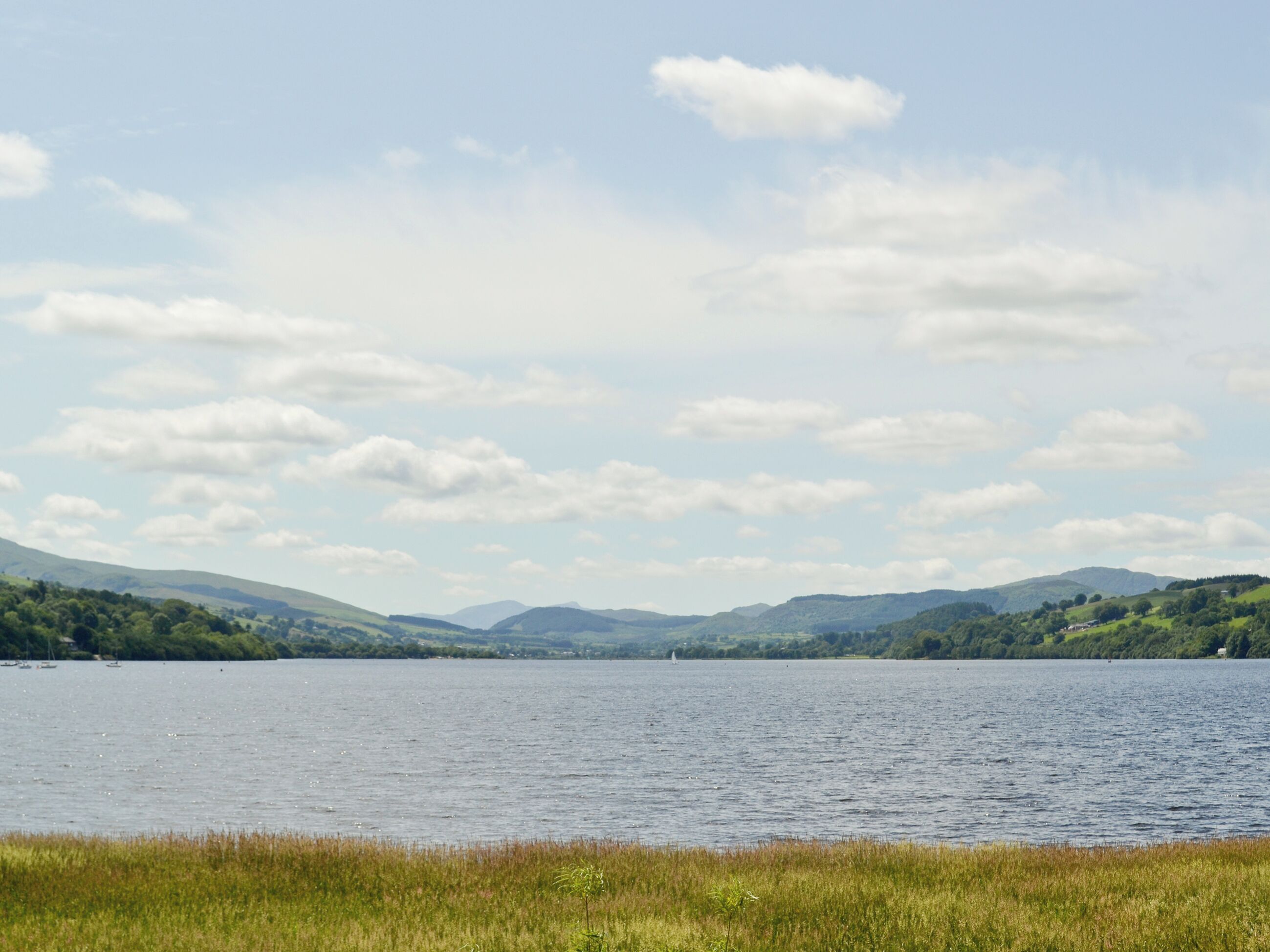 Un lago con cielo despejado y colinas al fondo.