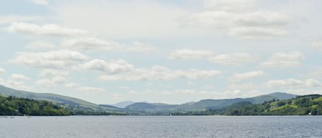 Un lago con cielo despejado y colinas al fondo.