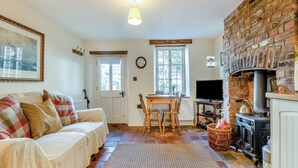 Una sala de estar acogedora con chimenea, comedor y televisor.