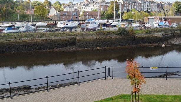 A marina with boats docked, a river, and a residential area with houses in the background. - 3 bedroom accommodation in Whitby (Whitby)
