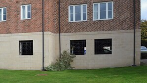 A multi-story brick building with multiple windows and a small garden area in front. - 3 bedroom accommodation in Whitby (Whitby)