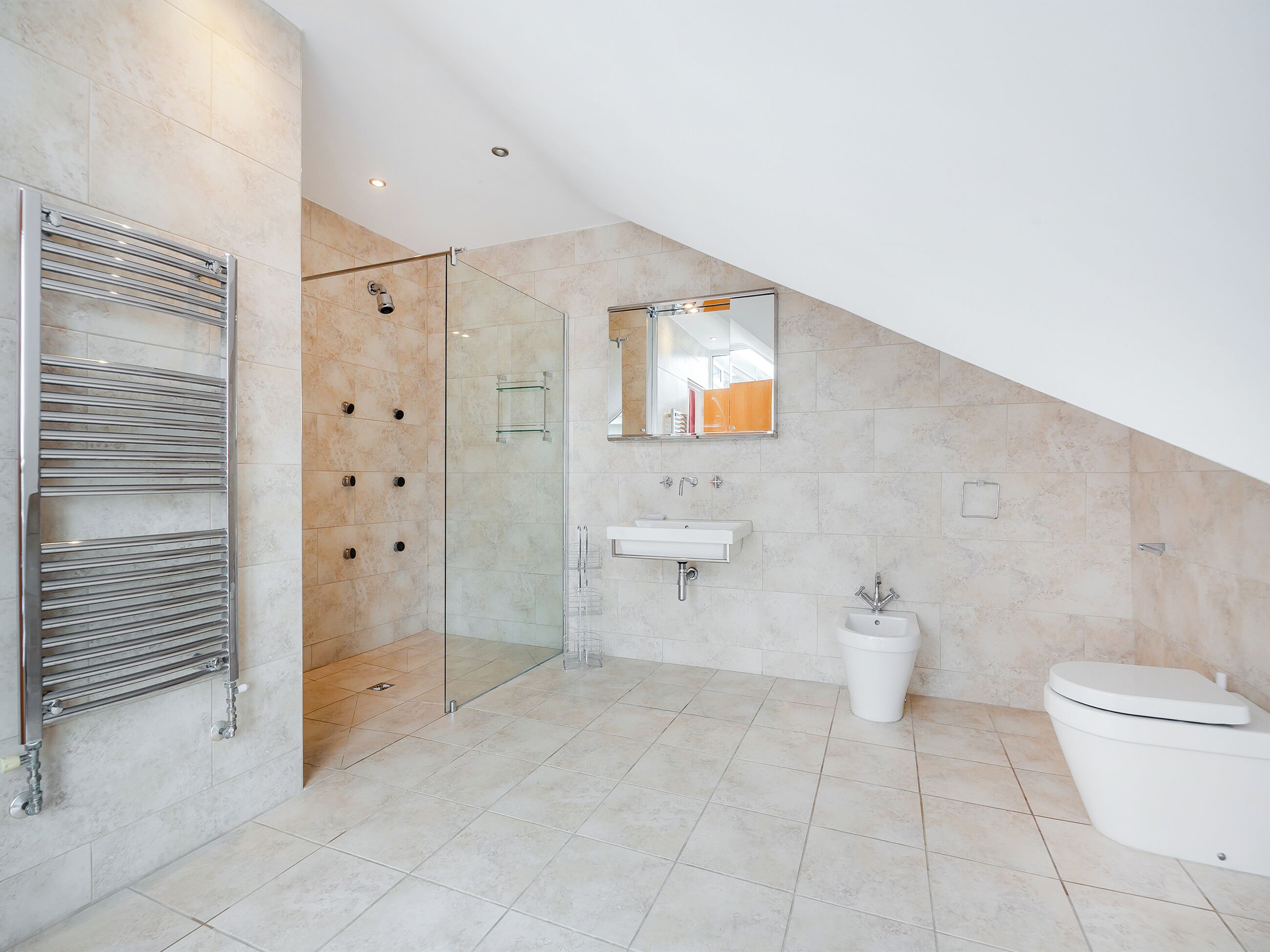 Une salle de bain moderne avec une douche à parois de verre, un lavabo intégré et des toilettes.