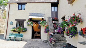 Ein charmantes Gebäude mit einer hölzernen Bank, einer Steintreppe und Blumenkästen.