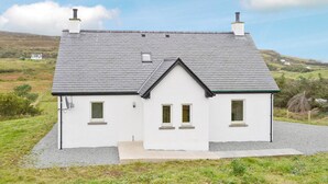 A white house with a grey roof, two chimneys, and a small window on the side. - 2 bedroom accommodation in Fasach, near Dunvegan (Fasach, near Dunvegan)