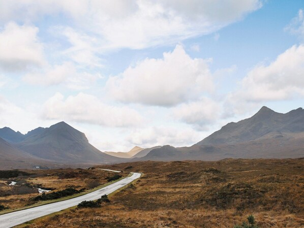 A winding road through a mountainous landscape with a clear sky.