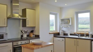 A modern kitchen with stainless steel appliances, wooden countertops, and a view of the outdoors through the windows. - 2 bedroom accommodation in Fasach, near Dunvegan (Fasach, near Dunvegan)
