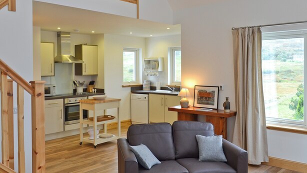 A modern kitchen with a dining area, a sofa, and a window with curtains. - 2 bedroom accommodation in Fasach, near Dunvegan (Fasach, near Dunvegan)