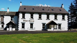 A two-story building with the name "Swan House" on the facade. It features a traditional architectural style with a pitched roof, multiple windows, and a front entrance with a door and a small porch. - 2 bedroom accommodation in Thornthwaite (Thornthwaite)