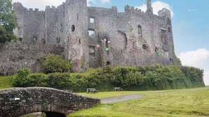 A historic castle with a stone bridge in the foreground. - Pendine Beach Apartment (Pendine, near Amroth)