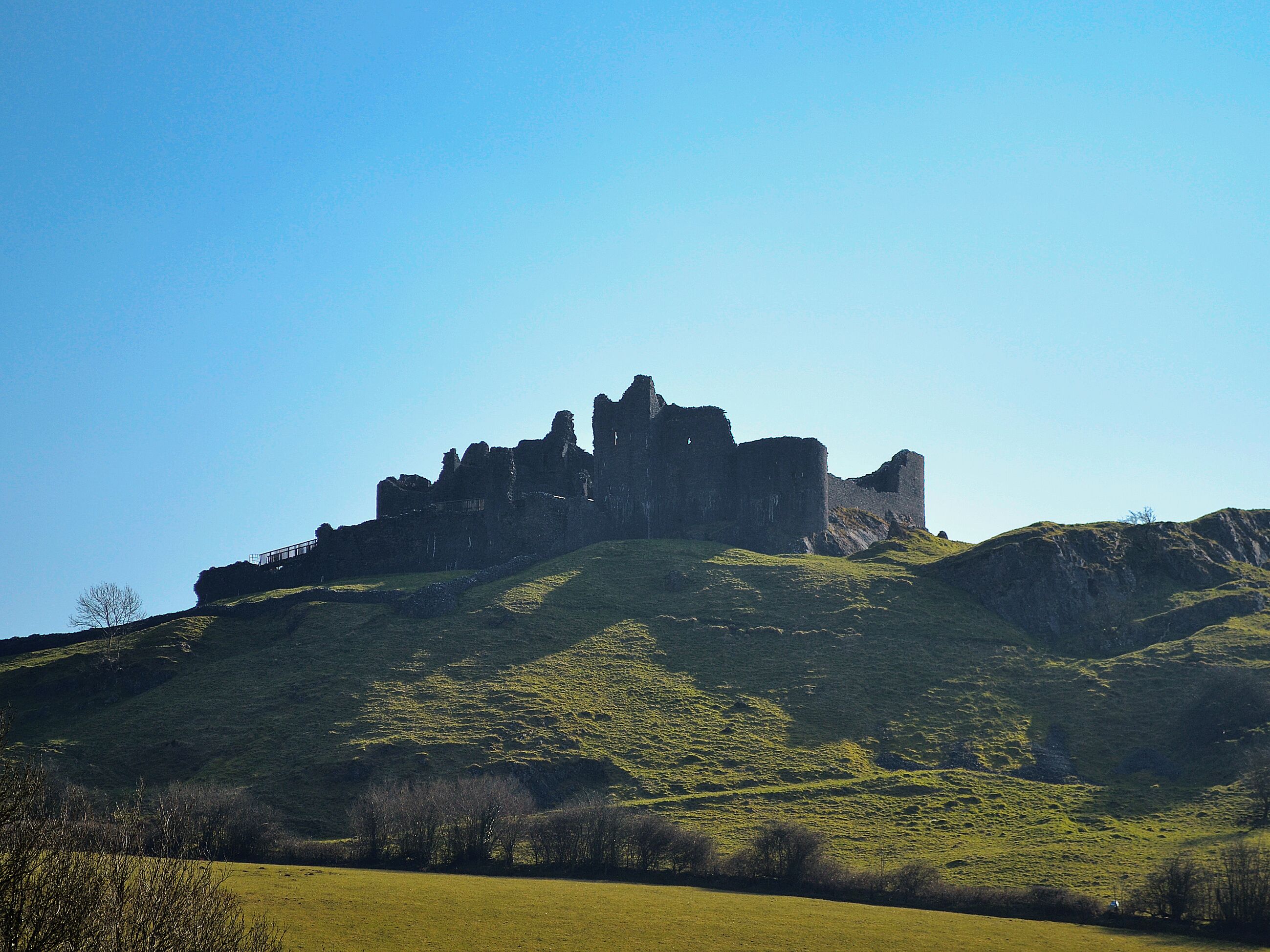 A historic castle on a hill with a clear sky.