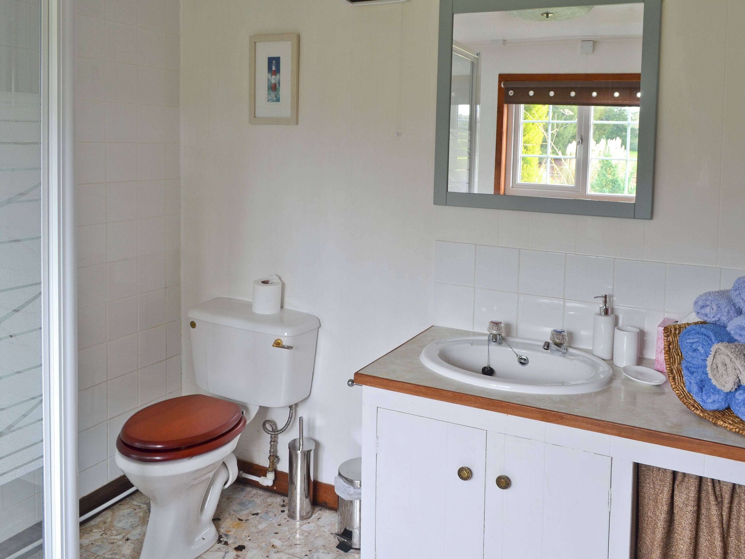 Ein Badezimmer mit Toilette, Waschbecken und Spiegel.