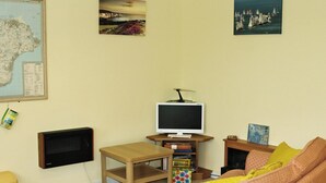 Ein Wohnzimmer mit Fernseher, einer Karte und einem Bücherregal.