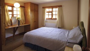 Ein Schlafzimmer mit einem Bett, einem Schreibtisch und einem Stuhl.