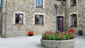 Un bâtiment en pierre doté de nombreuses fenêtres, d’une porte centrale et d’un lampadaire.