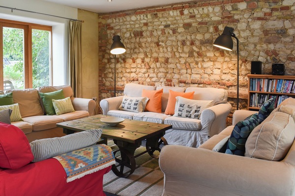Cosy and comfortable living room with feature stone wall | The Granary, Oxborough