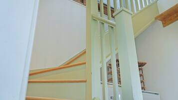 A staircase with wooden handrails and white walls.