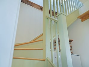 Eine Treppe mit hölzernen Geländern und weißen Wänden.
