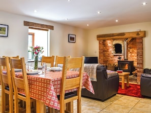 A dining area with a table set for four, wooden chairs, and a red and white checkered tablecloth.