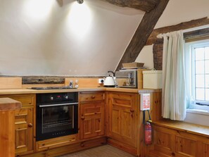 A kitchen with wooden cabinets, a stove, a toaster, and a fire extinguisher. - 1 bedroom accommodation in Walcot (Walcot)