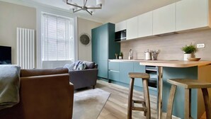 A modern kitchen with a central island, bar stools, and a built-in oven. - 2 bedroom accommodation in Portinscale, near Keswick (Portinscale, near Keswick)