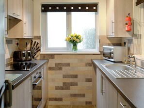 A modern kitchen with a window, a toaster, a microwave, and a sink.