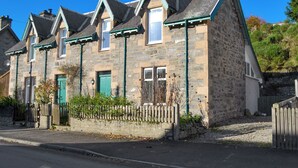 A row of stone houses with pitched roofs and green door frames. - 2 bedroom accommodation in Kingussie (Kingussie)