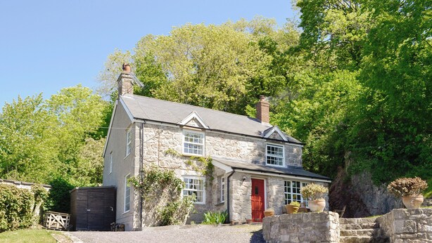A stone house with a red door, a gravel driveway, and a stone staircase leading to the entrance. - TY NEWYDD Y GRAIG - 28017 (Tremeirchion, near St. Asaph)