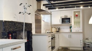 A modern kitchen with white cabinets, a built-in oven, a microwave, and a coffee maker. - 1 bedroom accommodation in Keswick (Keswick)
