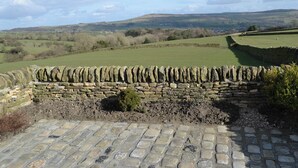 A stone wall with a cobblestone path leading to a green field. - Ground Floor: 
Open plan living space. (Silsden near Skipton)