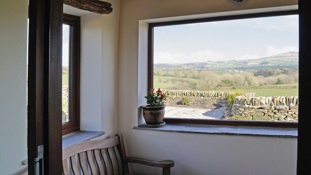 A room with a view of a stone wall and fields, a wooden bench, and a potted plant on a windowsill. - Ground Floor: 
Open plan living space. (Silsden near Skipton)