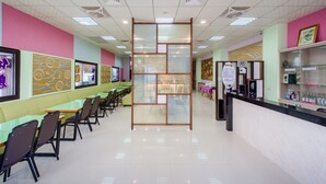 A restaurant with a long counter, multiple tables, and chairs. - Quan Ming Line Museum (Dahu)