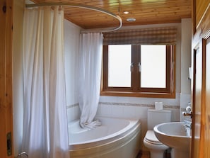 A bathroom with a bathtub, toilet, and sink.