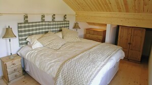 A bedroom with a bed, a nightstand, a dresser, and a wardrobe. - 2 bedroom accommodation in Fritton, near Great Yarmouth (Fritton, near Great Yarmouth)
