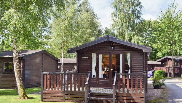 A small wooden cabin with a porch and a sign that reads "ASHNESS". - 1 bedroom accommodation in Keswick (Keswick)