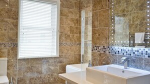 Un bagno con uno specchio grande, una vasca e un lavandino.