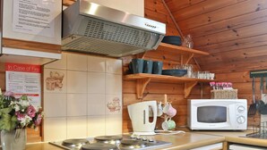 A kitchen with a stove, microwave, and a coffee maker. - 2 bedroom accommodation in Blair Atholl near Pitlochry (Blair Atholl near Pitlochry)
